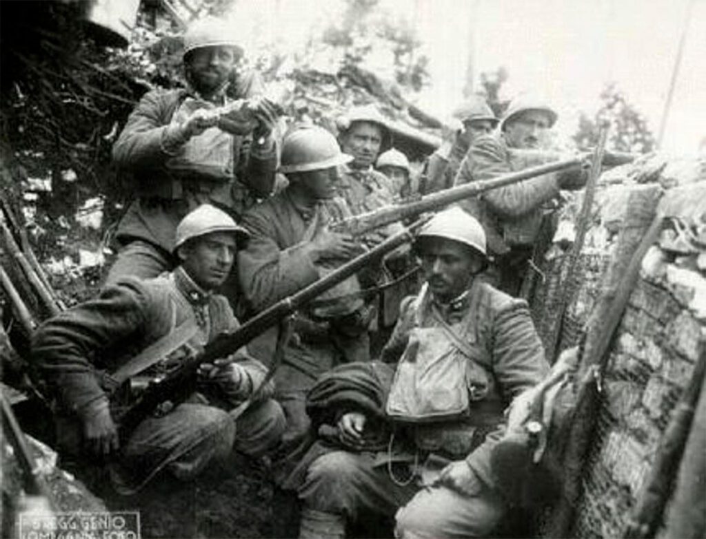 Grupo de soldados italianos con cascos Adrian y fusiles en el interior de una trinchera durante la Gran Guerra.