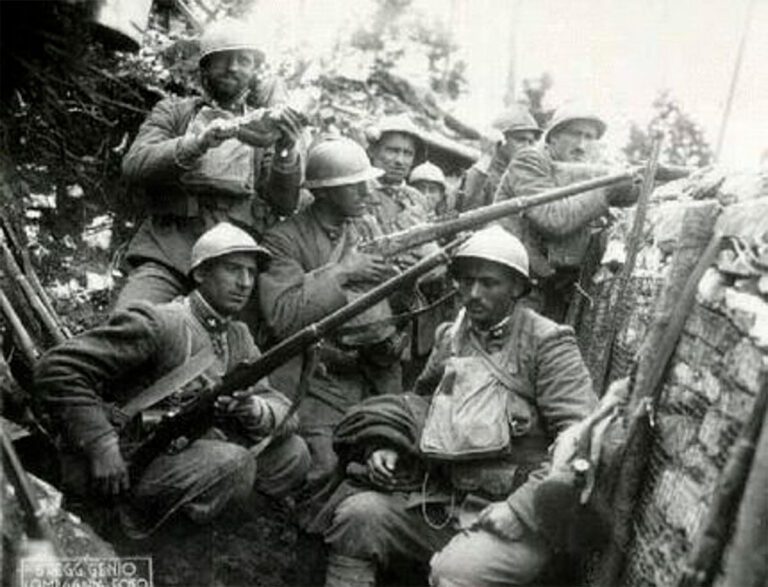 Grupo de soldados italianos con cascos Adrian y fusiles en el interior de una trinchera durante la Gran Guerra.
