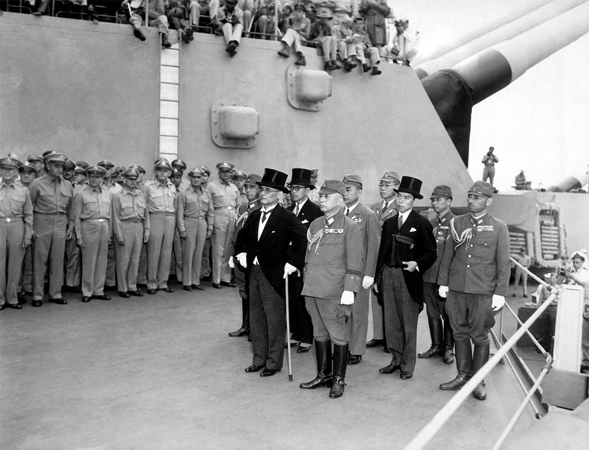 Delegación japonesa vestida de gala y uniformes militares llegando a la cubierta del USS Missouri para la ceremonia de rendición.