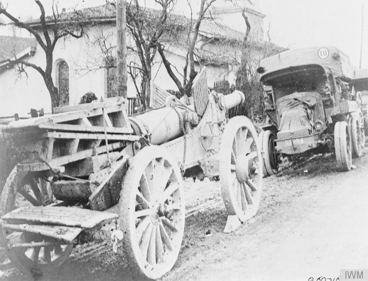 Soldados exhaustos regresan por una ciudad europea devastada con civiles entre ruinas y un edificio imperial dañado al fondo, tras la Primera Guerra Mundial.