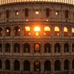 Vista frontal del Coliseo Romano completo durante la dinastía Flavia al atardecer, con el sol brillando a través de sus arcos superiores, estatuas en los nichos y ciudadanos romanos caminando en la base.